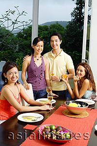 Asia Images Group - Young adults around dinner table, smiling at camera