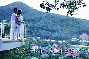 Asia Images Group - Couple standing on balcony looking out at view