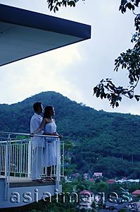 Asia Images Group - Couple standing on balcony, side view