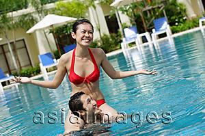 Asia Images Group - Woman sitting on mans shoulders in swimming pool