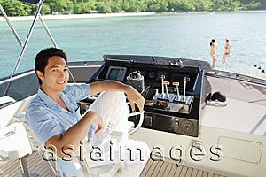 Asia Images Group - Man sitting at helm of yacht, portrait