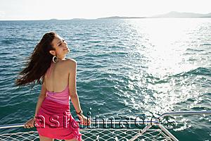 Asia Images Group - Woman on boat, standing next to railing, enjoying breeze