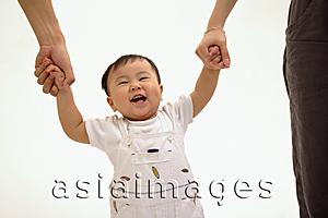 Asia Images Group - Young boy holding hands with his parents