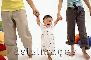 Asia Images Group - Baby boy walking between his parents