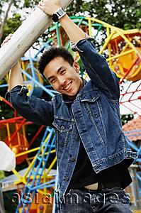 Asia Images Group - Young man at playground, smiling at camera