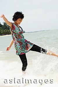 Asia Images Group - Woman on beach, kicking water