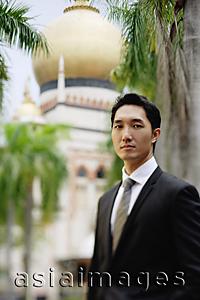 Asia Images Group - Businessman standing, looking at camera, mosque in the background