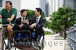 Asia Images Group - Two businessmen riding in trishaw