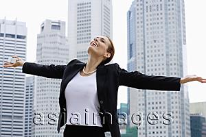 Asia Images Group - Businesswoman with arms outstretched, looking up