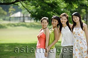 Asia Images Group - Young women standing side by side, smiling at camera