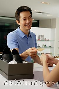 Asia Images Group - Man paying for shoe purchase