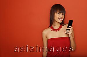 Asia Images Group - Young woman in red tube top with mobile phone