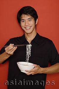 Asia Images Group - Man holding bowl of noodles