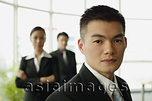 Asia Images Group - Businessman looking at camera, people in the background