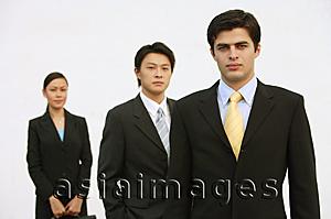 Asia Images Group - Business people standing, looking at camera, in a row
