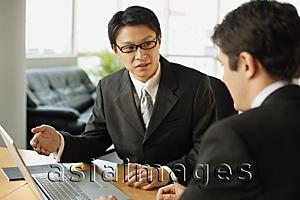 Asia Images Group - Businessmen having a discussion, laptop on desk in front of them