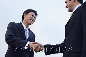Asia Images Group - Businessmen shaking hands, low angle view