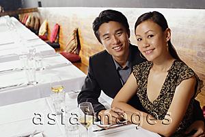 Asia Images Group - Couple sitting in restaurant, smiling at camera