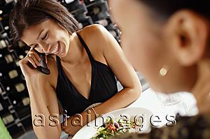Asia Images Group - Woman at restaurant table, using mobile phone
