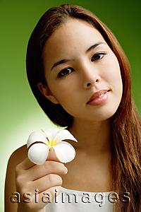 Asia Images Group - Young woman holding Frangipani flower