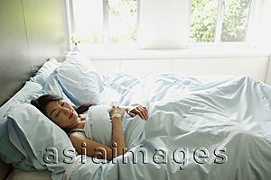 Asia Images Group - Woman sleeping in bedroom