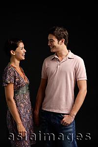 Asia Images Group - Couple standing, smiling at each other