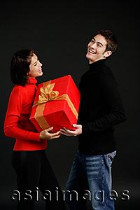 Asia Images Group - Man passing gift to woman