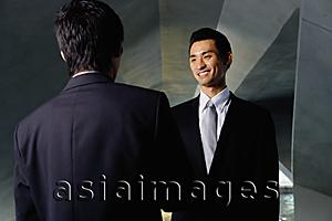 Asia Images Group - Two businessmen shaking hands, over the shoulder view