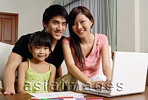 Asia Images Group - Family with one daughter, looking at camera, mother using laptop