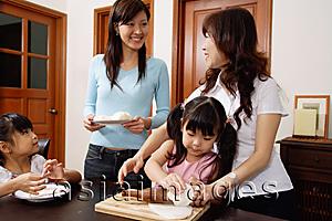 Asia Images Group - Grandmother with daughter and two granddaughters at home, making dough