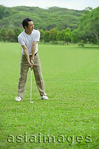 Asia Images Group - Man preparing to drive golf ball