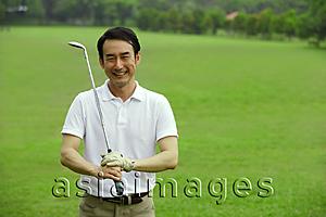 Asia Images Group - Man holding golf club, smiling at camera