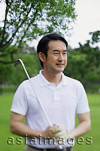 Asia Images Group - Man holding golf club, looking away, portrait