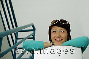 Asia Images Group - Woman sitting on stairs, leaning on laptop, smiling