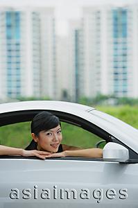 Asia Images Group - Woman in front seat of car, leaning on window, smiling at camera