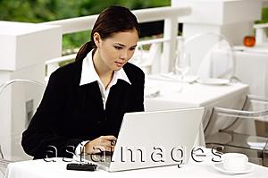 Asia Images Group - Businesswoman sitting in restaurant, using laptop