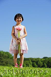 Asia Images Group - Girl wearing pink dress, holding bouquet of flowers