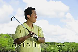 Asia Images Group - Man with gold club over his shoulder, looking away