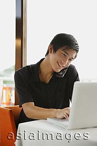 Asia Images Group - Man using laptop and mobile phone
