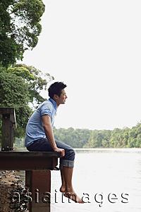 Asia Images Group - Man sitting on jetty, smiling