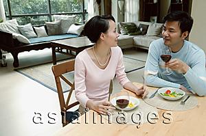 Asia Images Group - Couple sitting at dining table eating