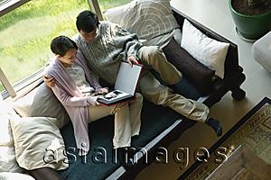 Asia Images Group - Couple at home looking a photo album