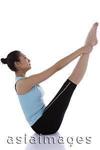 Asia Images Group - Female gymnast holding her ankles, stretching