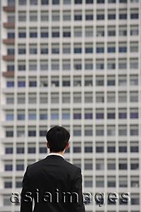 Asia Images Group - Businessman looking at building, rear view