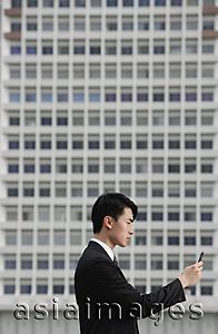 Asia Images Group - Businessman with mobile phone, side view
