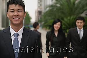 Asia Images Group - Businessman looking at camera, people in the background