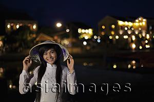 Asia Images Group - Young woman wearing traditional Vietnamese outfit at night, Vietnam