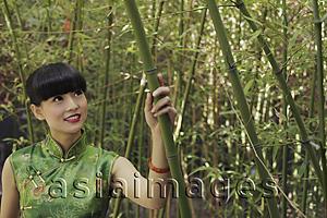 Asia Images Group - Young woman wearing traditional Chinese dress standing in bamboo forest