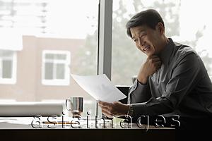 Asia Images Group - Mature man working near a window in an office