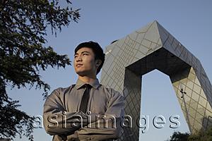 Asia Images Group - Young man standing in front of CCTV Building, Beijing, China